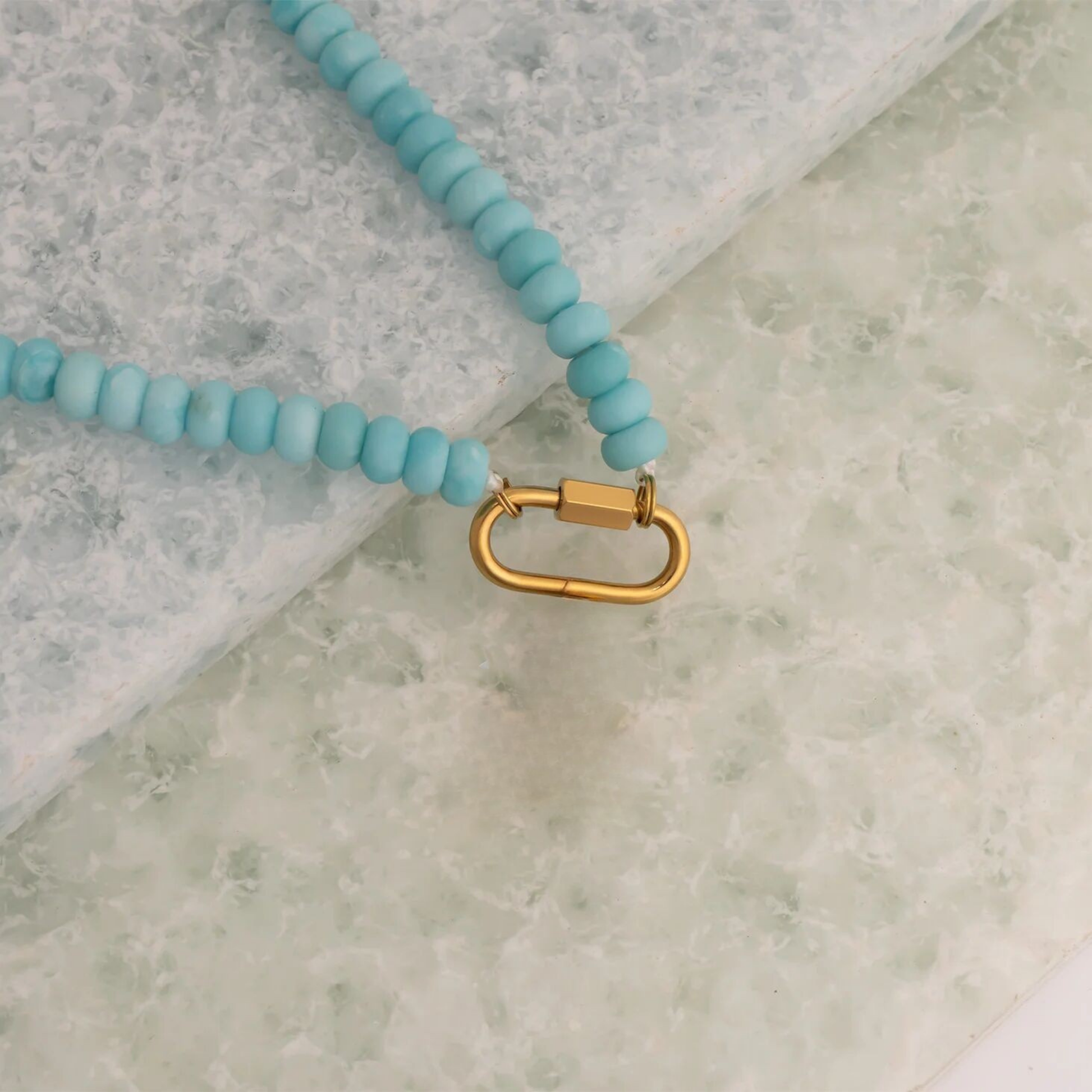 Close-up of 18K gold PVD carabiner clasp on turquoise beaded necklace