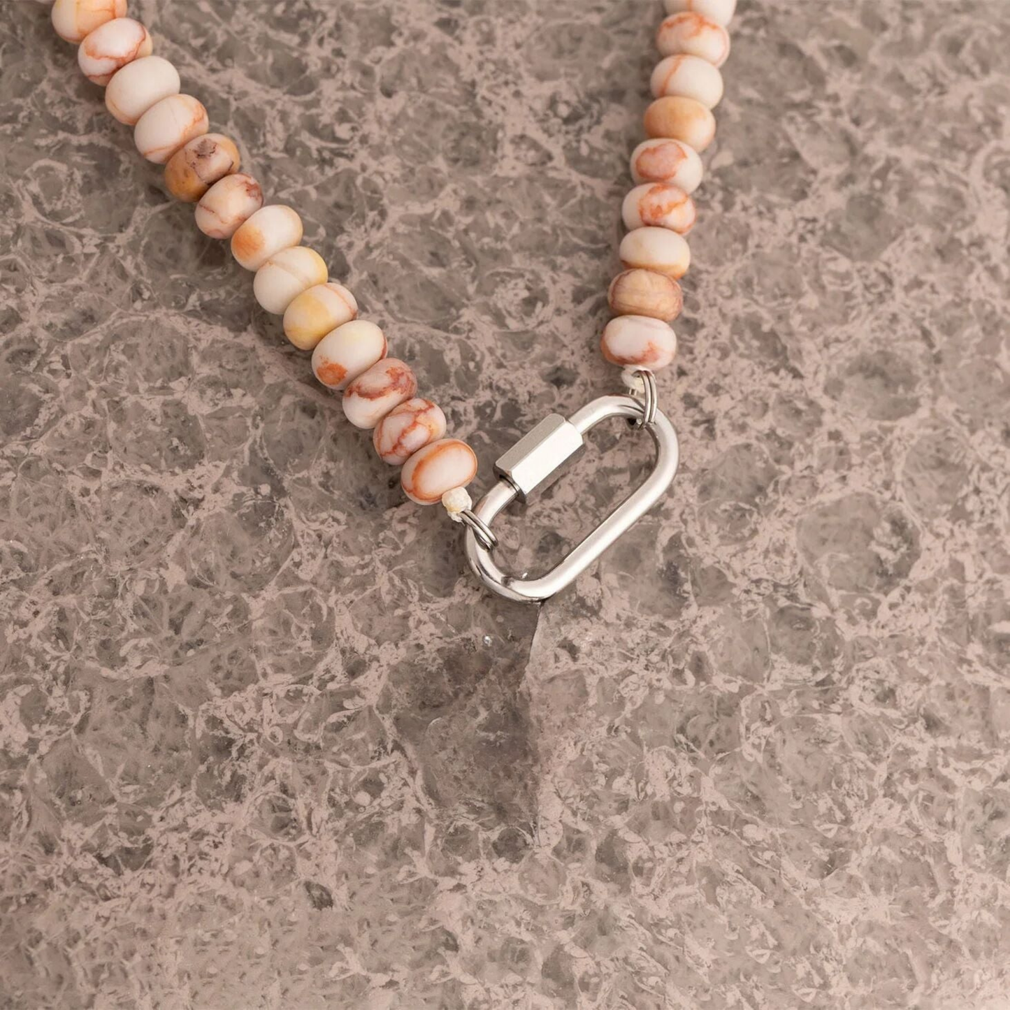 Close up of blush marble bead necklace with silver carabiner clasp on model