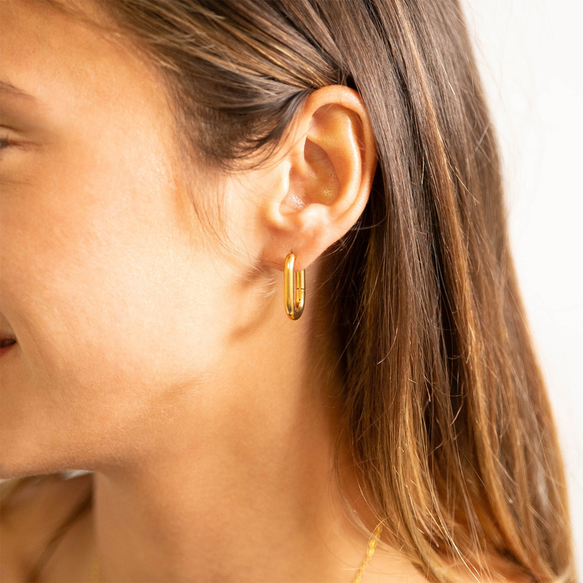 Woman wearing NEMOSN FormaLink Gold Oval Hoop Earrings