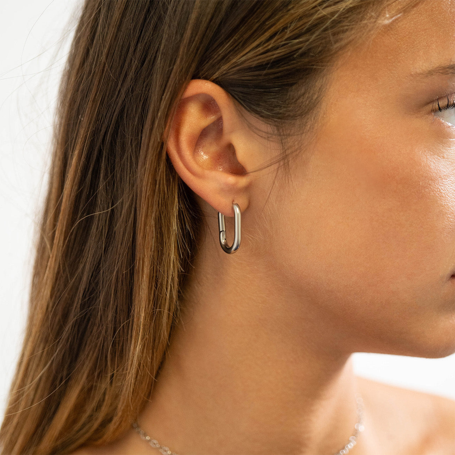 Woman wearing NEMOSN FormaLink Silver Oval Hoop Earrings