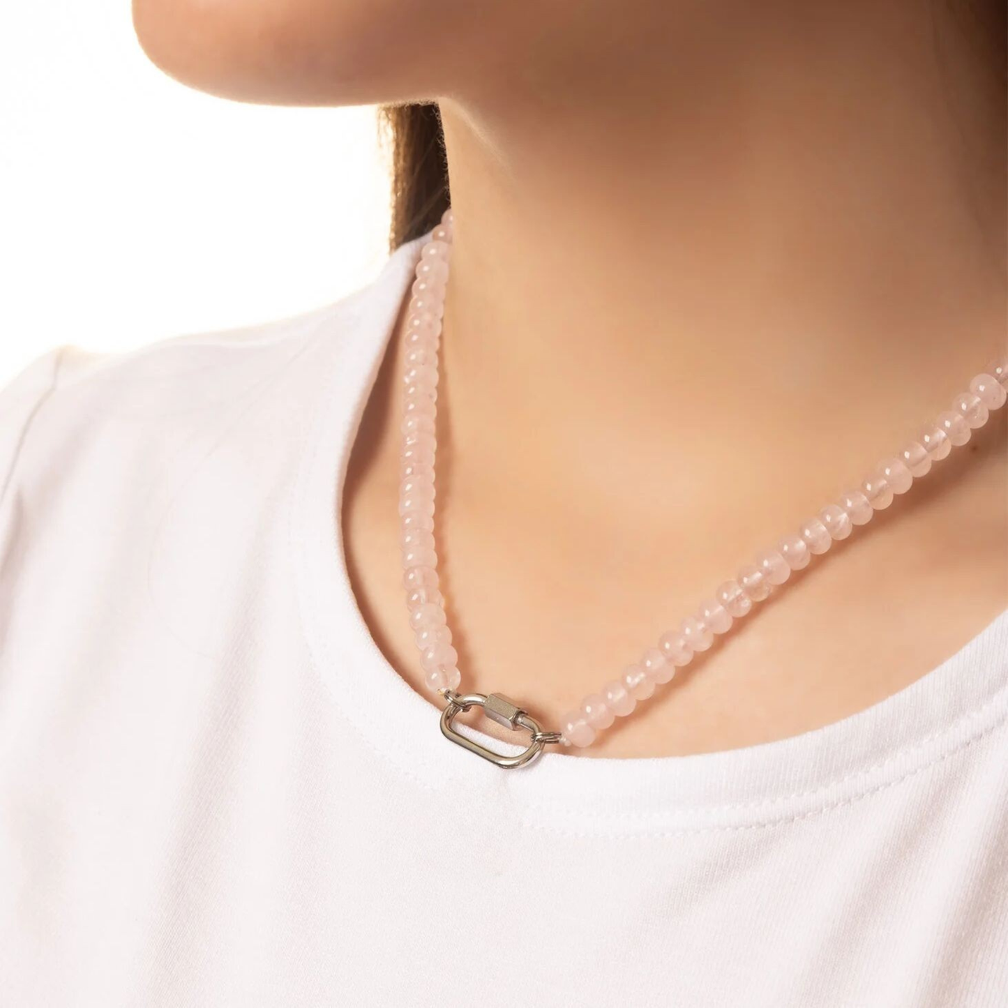 Woman wearing rose quartz gemstone necklace with silver carabiner clasp